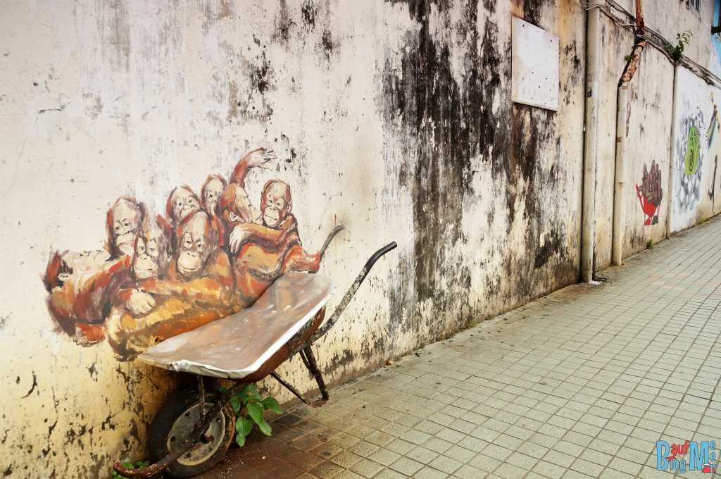 Sprayerkunst: Junge Orangutans in Schubkarre in Kuching